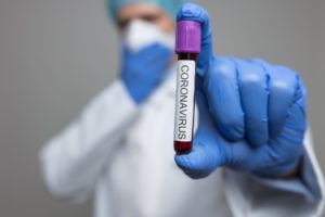 Doctor wearing respiratory mask and holding the Coronavirus blood sample